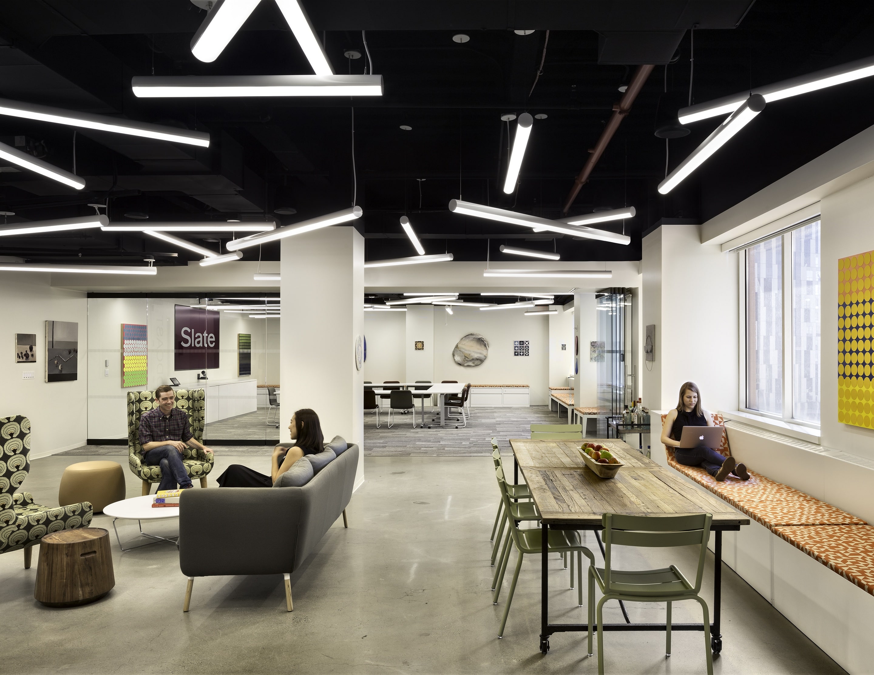 A large open lounge area. With a folding glass partition wall in the background.
