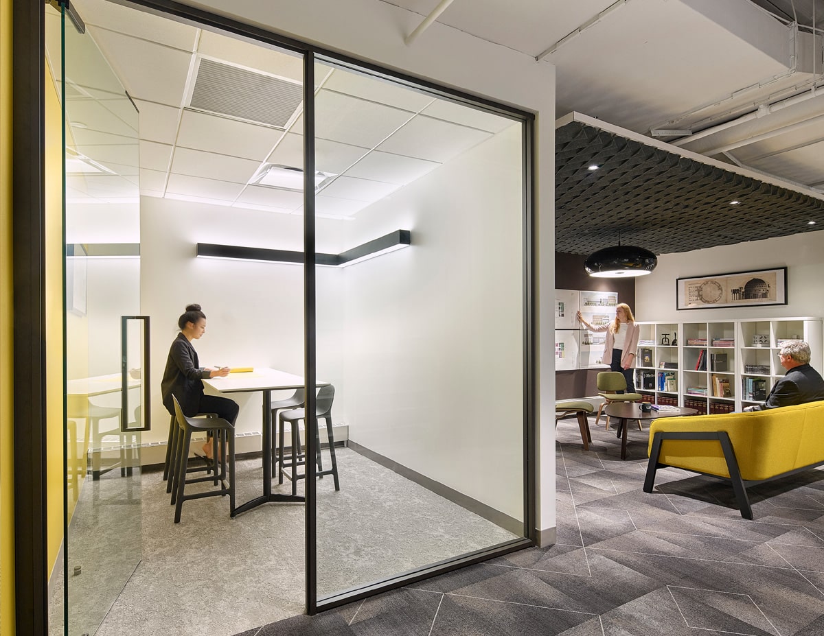 Three free standing desk dividers in an office with three yellow chairs